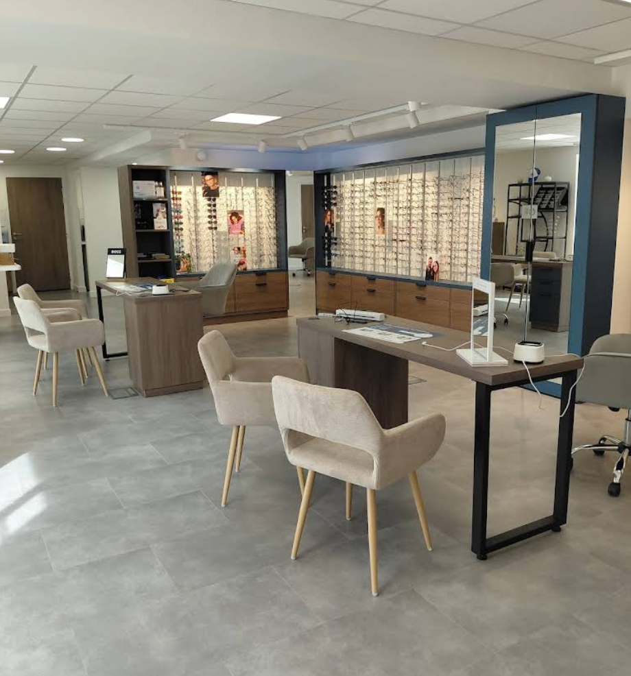 Vue d'ensemble du magasin d'optique de Pleucadeuc avec mobilier sur mesure, espaces de conseil et présentation des collections de lunettes.