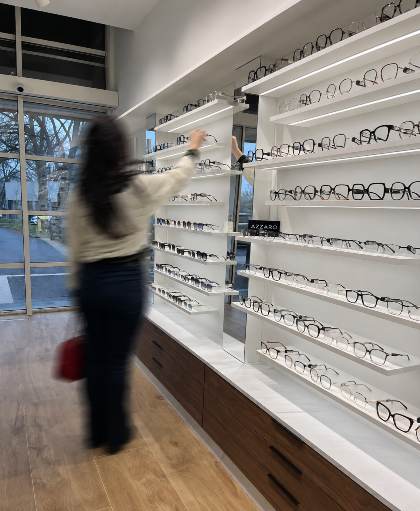 Cliente découvrant les collections de lunettes dans le magasin Optic & You à Mulhouse équipé d’un mobilier d’agencement sur mesure