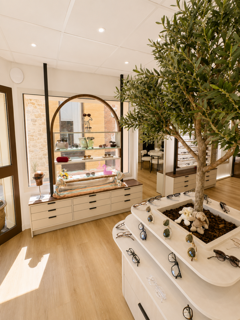 Vitrine estivale de lunettes de soleil et podium végétalisé au Comptoir de l'Optique